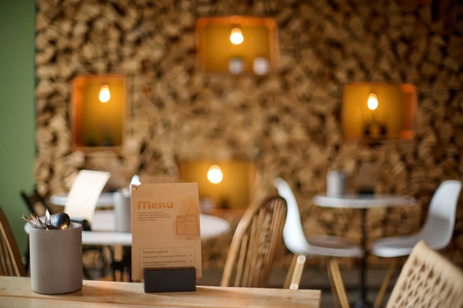 Inside Napata: warm lighting against the signature woodpile wall