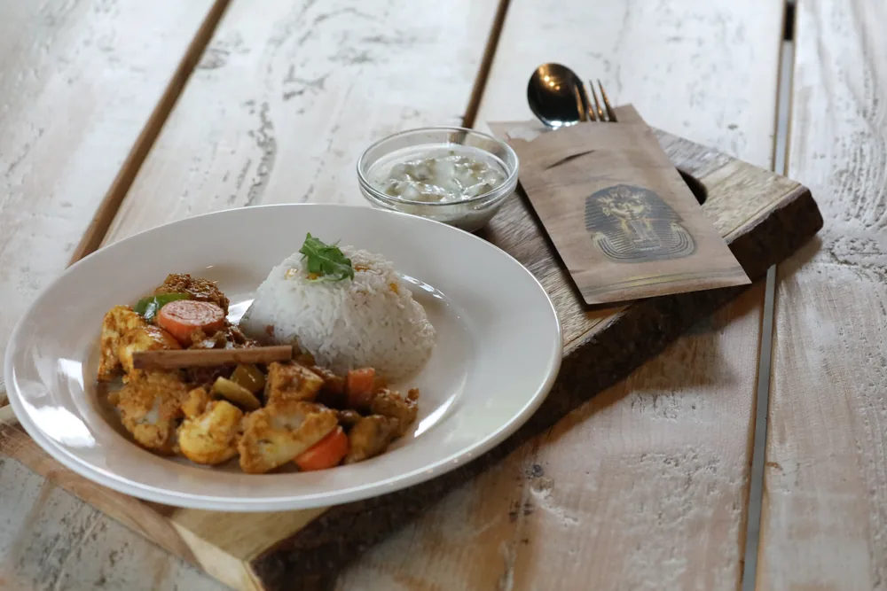 A Sudanese dinner plate — slow-cooked stew with rice and fresh salad