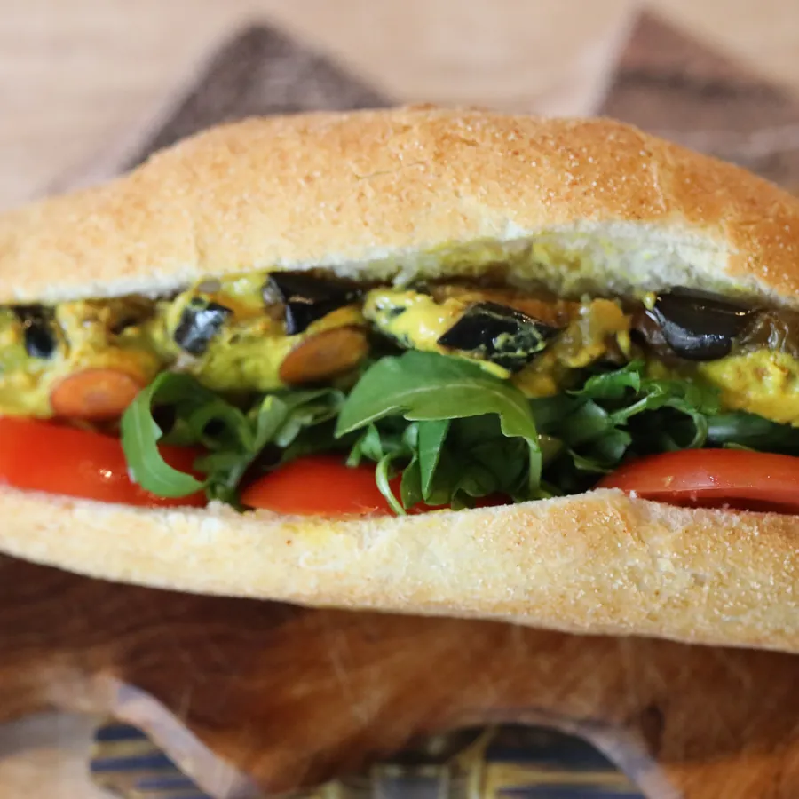A falafel sandwich with fresh tomato and soft white cheese