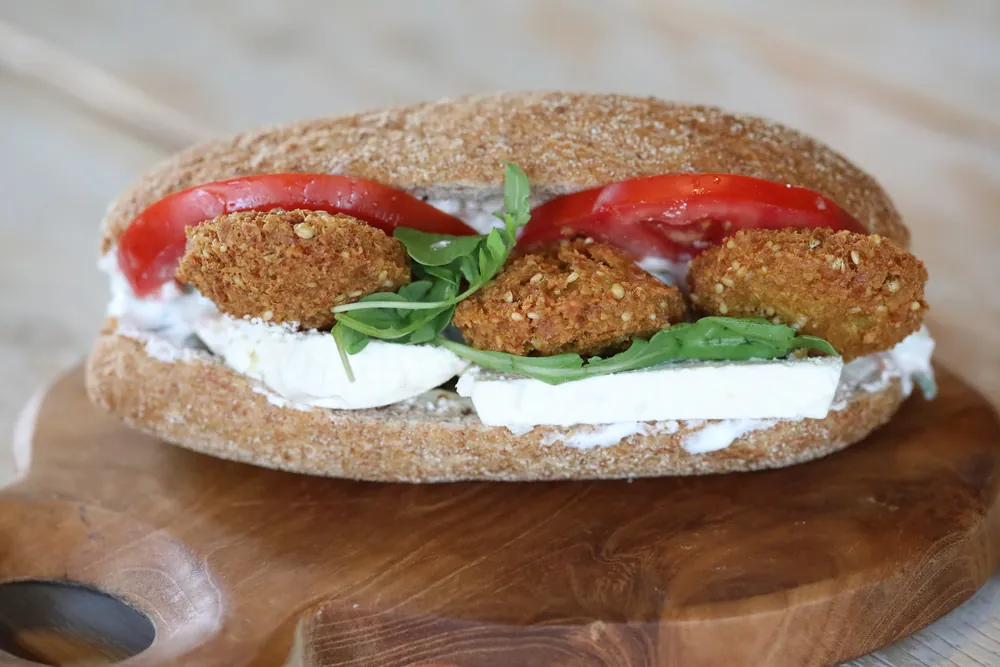 A crisp falafel sandwich layered with tomato and rocket