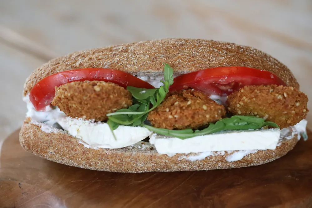 A falafel sub with tomato and creamy dressing