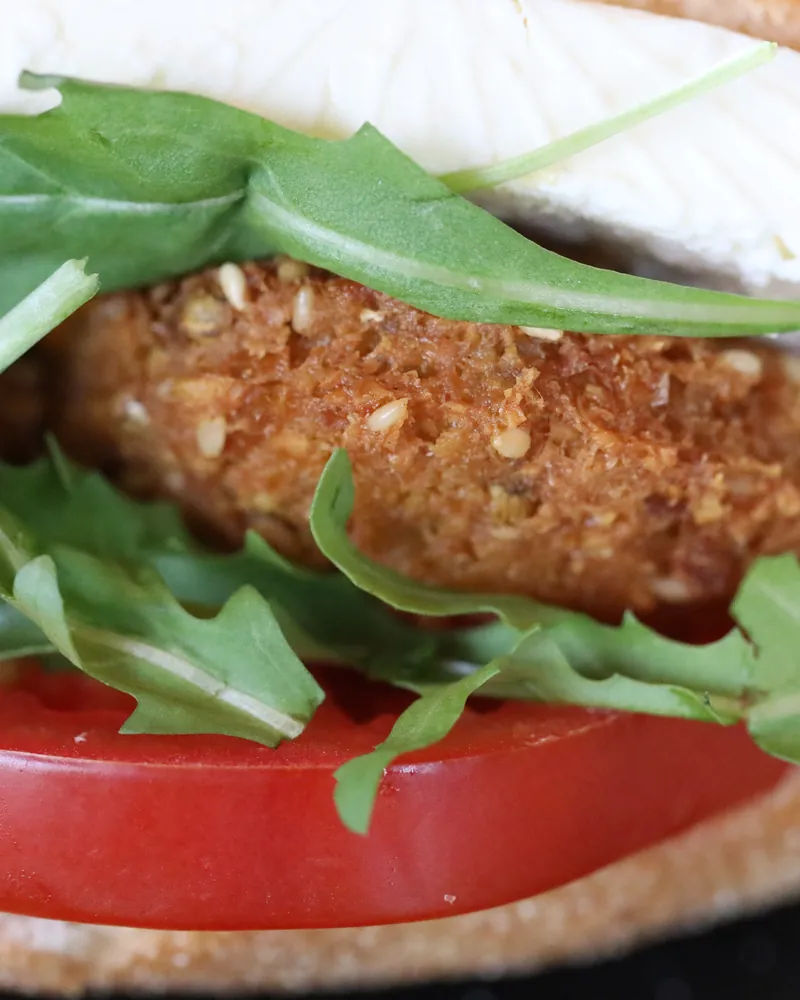 A single falafel patty on tomato with rocket