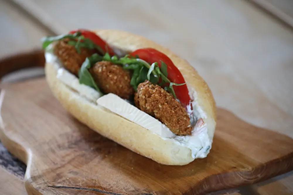 Two falafel patties in a soft roll with tomato
