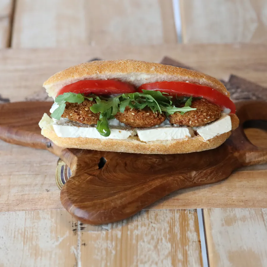 A falafel sandwich on a rustic serving board