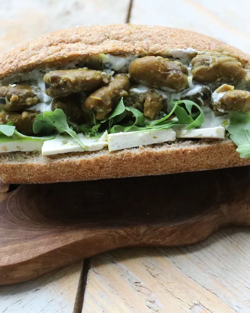 A wholemeal roll of stewed fava beans and greens
