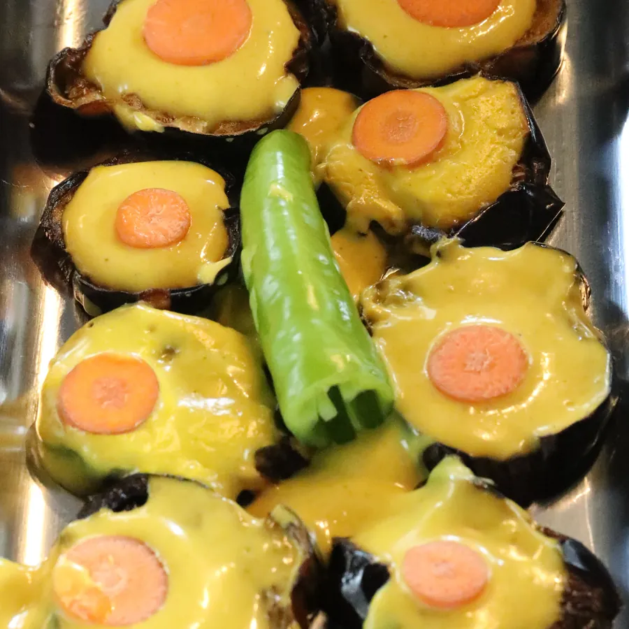 Close view of golden-glazed aubergine with green chilli