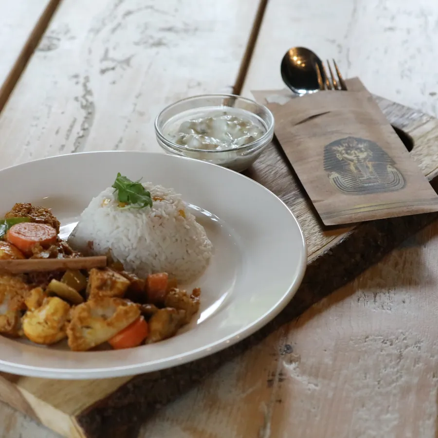 Spiced chicken and rice served on a wooden board