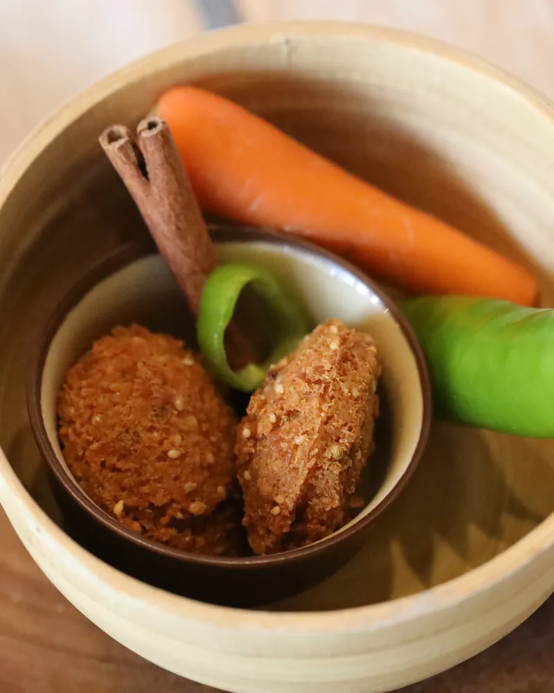 Falafel with fresh carrot and green pepper in a wooden bowl