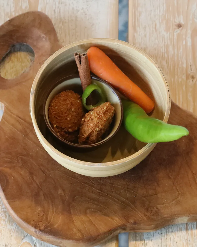 Falafel served in a carved bowl with raw vegetables